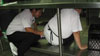 Aida Aguon, Special Diet Assistant, finds room to share underneath the kitchen counter when taking cover during the Shake Out drill.